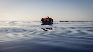 Migrants  in a wooden boat as they are being rescued, Aug. 27, 2022.