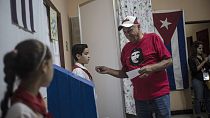 Egy Che Guevara arcképét viselő férfi készül szavazni Havannában