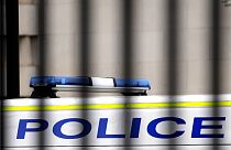 A police van is parked behind railings in Westminster in London, Tuesday, March 21, 2023.