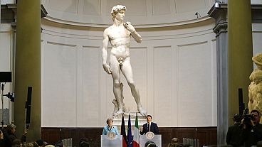 Former German Chancellor Angela Merkel and ex-Italian Prime Minister Matteo Renzi holding a press conference in front of Michelangelo's David in 2015.