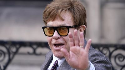 Elton John waves to the waiting media as he leaves the Royal Courts Of Justice in London, Monday, March 27, 2023.