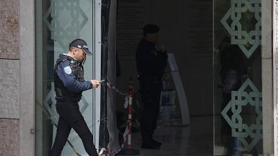 A police officer walks at the entrance of an Ismaili Muslim center in Lisbon, Portugal