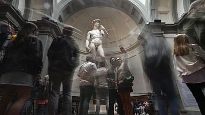 Tourists take photos in front of Michelangelo's "David statue" in the Accademia Gallery in Florence, Italy.