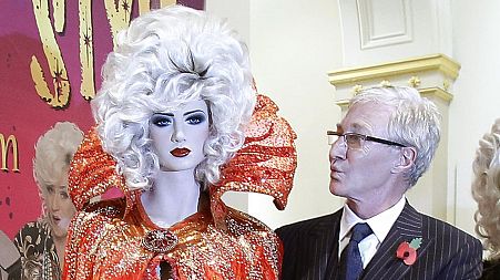 O'Grady standing next to a costume of his alter ego Lily Savage - Liverpool's Walker Art Gallery