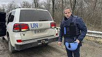 In this photo provided by the IAEA Press Office, UN atomic energy chief Rafael Mariano Grossi stands on a road next to a UN vehicle on his way to the Zaporizhzhia Plant.