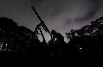 دختری از طریق تلسکوپ در کاراکاس، ونزوئلا به ماه نگاه می‌کند
