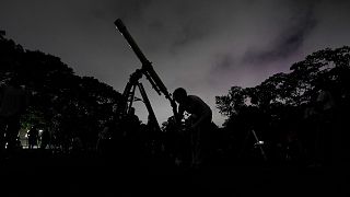دختری از طریق تلسکوپ در کاراکاس، ونزوئلا به ماه نگاه می‌کند
