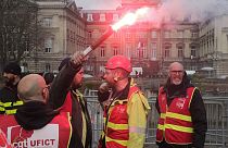 CGT union member raises a flare during a demonstration in Lille, northern France Thursday March 30, 2023. 