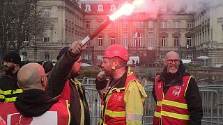 CGT union member raises a flare during a demonstration in Lille, northern France Thursday March 30, 2023.