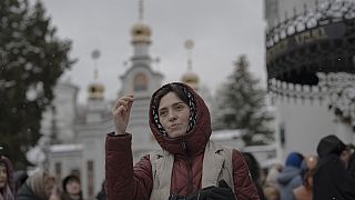 Des personnes prient dans le complexe du monastère de Kyiv Pechersk Lavra à Kyiv, en Ukraine, le mercredi 29 mars 2023.