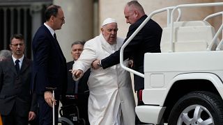 Pope Francis gets help from his security people. 