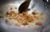 Pieces of guanciale (pork cheek) are sizzled in a pan during a cooking competition on the eve of the Carbonara Day, an event created by the the Italian Food Union, in Rome.