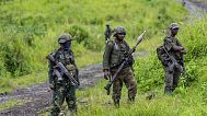 M23 rebels stand with theirs weapons during a ceremony to mark the withdrawal from their positions in the town of Kibumba, in the eastern of Democratic Republic of Congo, on D