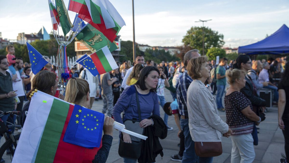 Женщина продает флаги Болгарии и ЕС сторонникам партии НП во время заключительного предвыборного митинга в столице Болгарии Софии в пятницу, 9 сентября. 30 декабря 2022 г. 
