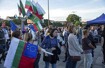 A woman sells Bulgarian and EU flag to supporters of the PP party during the closing election rally in capital Sofia, Bulgaria on Friday, Sept. 30, 2022.