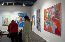 Les visiteurs regardent les œuvres d'art exposées sur l'un des stands d'Art Paris.