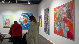 Les visiteurs regardent les œuvres d'art exposées sur l'un des stands d'Art Paris.