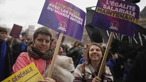 Frauen demonstrieren mit Plakaten mit der Aufschrift "Gleicher Lohn jetzt" in Paris, 8. März 2023.
