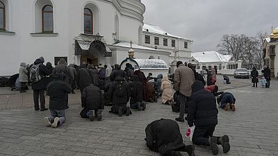 People pray in the Kyiv Pechersk Lavra monastery complex in Kyiv, Ukraine, Wednesday, March 29, 2023.