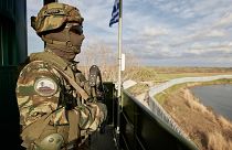 Greek soldier guards over a border wall along the Evros River which forms the frontier between Greece and Turkey, on Friday, March 31, 2023.