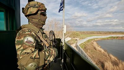 Greek soldier guards over a border wall along the Evros River which forms the frontier between Greece and Turkey, on Friday, March 31, 2023.
