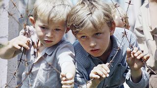 Two Bosniak boys pictured in group of refugees from Mostar, Zepa and other Bosnian areas besieged by Serbian and Croatian converge in Zenica, 13 May 1993.