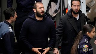 الشرطة ترافق أندرو تيت في الوسط وهو مكبل اليدين مع شقيقه تريستان تيت إلى محكمة الاستئناف في بوخارست - رومانيا. 2023/02/27