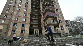 Un residente local monta en bicicleta junto a un edificio residencial dañado tras un ataque con misiles rusos en la ciudad de Kostyantynivka.