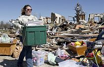 Betty Monroe ayuda a una compañera de trabajo cuya casa fue destruida unos días antes por un tornado que arrasó la zona sur de Sullivan, Indiana, el domingo 2 de abril de 2023