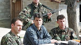 Hashim Thaçi, au Kosovo, en 1999, entouré par des hommes armés