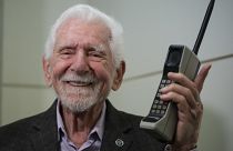 Marty Cooper posiert mit einem Motorola DynaTAC 8000x auf dem Mobile World Congress 2023 in Barcelona.