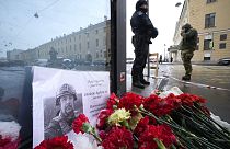 Flowers and a poster with a photo of blogger Vladlen Tatarsky placed near the site of an explosion at the "Street Bar" cafe in St. Petersburg, Russia, Monday, April 3, 2023.