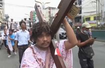 Manifestante carrega grande cruz pelas ruas da capital das Filipinas