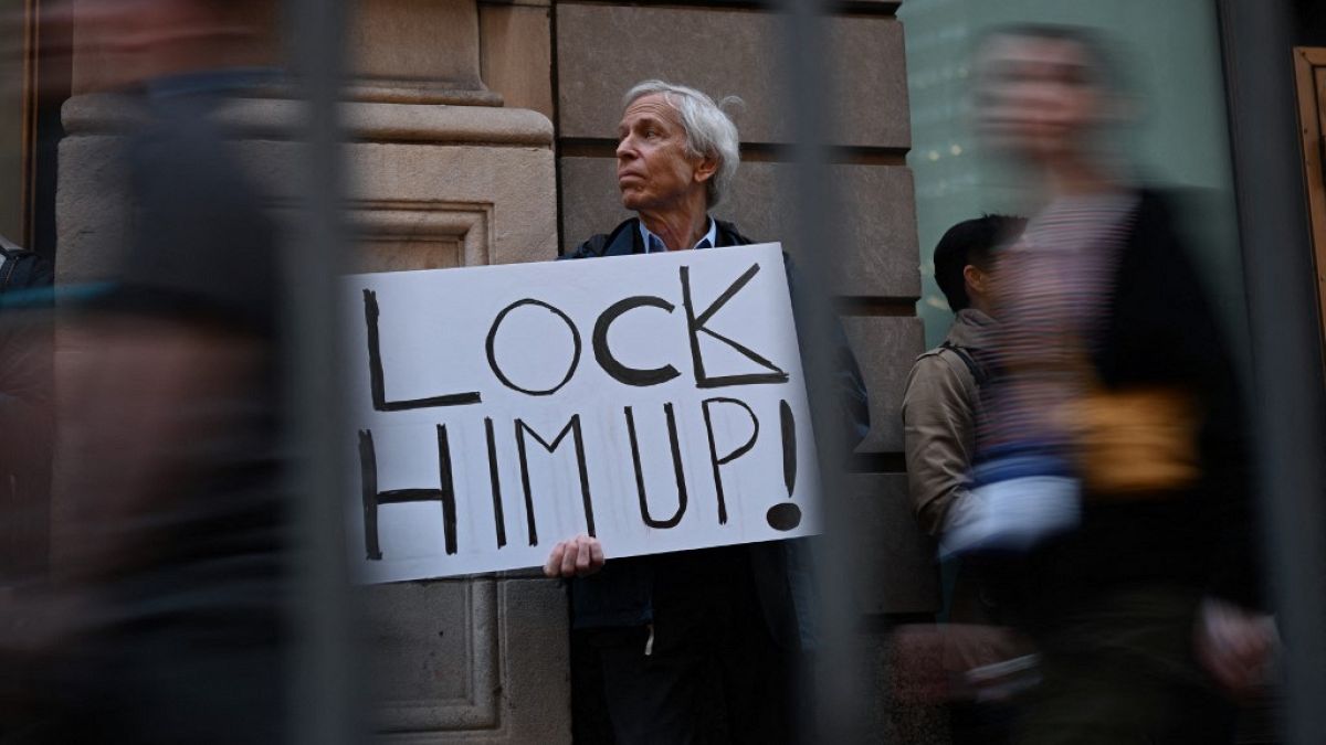 Противник Трампа с плакатом "Заключите его под стражу!"