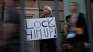 Противник Трампа с плакатом "Заключите его под стражу!"