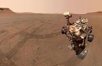 تصویری از مريخ نورد استقامت در حال جمع آوری نمونه سنگ‌ها در سیاره مريخ.