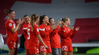 Switzerland players applaud next to a giant Swiss flag at the end of the FIFA Women's World Cup 2023 between Switzerland and Moldova on September 6, 2022.
