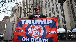مؤيد لترامب أمام مقر المحكمة في نيويورك يرفع راية كتب عليها "ترامب أو الموت"