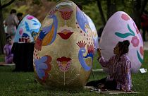 Pepa Espinoza paints an Easter egg along with other artists