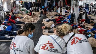 This handout picture released on November 17, 2021, by Doctors Without Borders (MSF) shows MSF members resting on the Geo Barents crew after rescuing migrants.