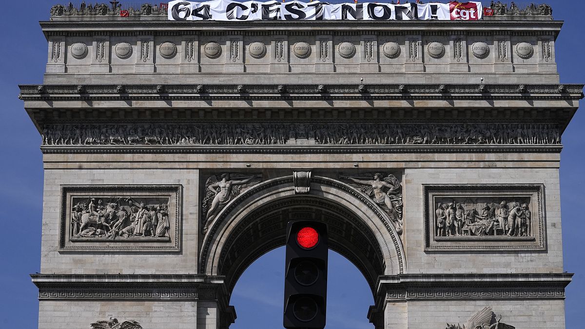 النقابيون في "سي جي تي" يعلقون لافتة عملاقة كتب عليها "64 ، لا" على قمة نصب قوس النصر في باريس. 202/04/05