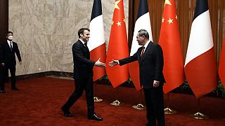 El presidente de Francia, Emmanuel Macron, saluda al primer ministro chino Li Qiang, en Pekín, el 6 de abril de 2023