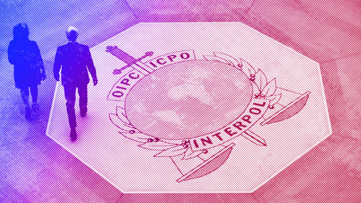 People walk on the Interpol logo at the international police agency headquarters in Lyon, November 2018