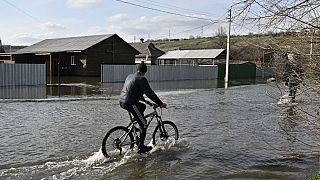 Un ciudadano de Kramatorsk monta en bicicleta en medio de las inundaciones de la ciudad