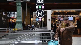 Un passager regard sa montre dans la garde du Nord, à Paris, lieu de croisement de nombreuses lignes de métro et de RER.