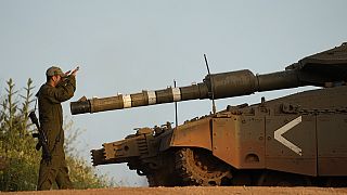 Ein israelische Soldat dirigiert einen Panzer an der israelisch-libanesischen Grenze, nach einem Raketenangriff aus dem Libanon