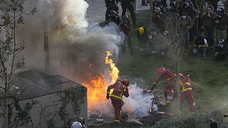 Firefighters extinguish a fire at the end of the demonstration Thursday, April 6, 2023 in Paris.