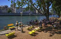 People enjoy the sun at Paris Plage event along the Seine River in Paris, Sunday, July 10, 2022.