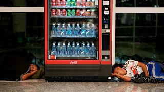 Des sans-abri dorment de part et d'autre d'un distributeur automatique à l'aéroport international d'Aeroparque, à Buenos Aires (Argentine) - 06.04.2023