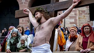 Ein Laienschauspieler wird während der Karfreitagsprozession in Bensheim, Deutschland ans Kreuz geschlagen.